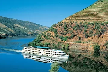 Le bateau Douro Spirit longeant les montagnes majestueuses lors de la croisière dans la vallée du Douro en bateau.